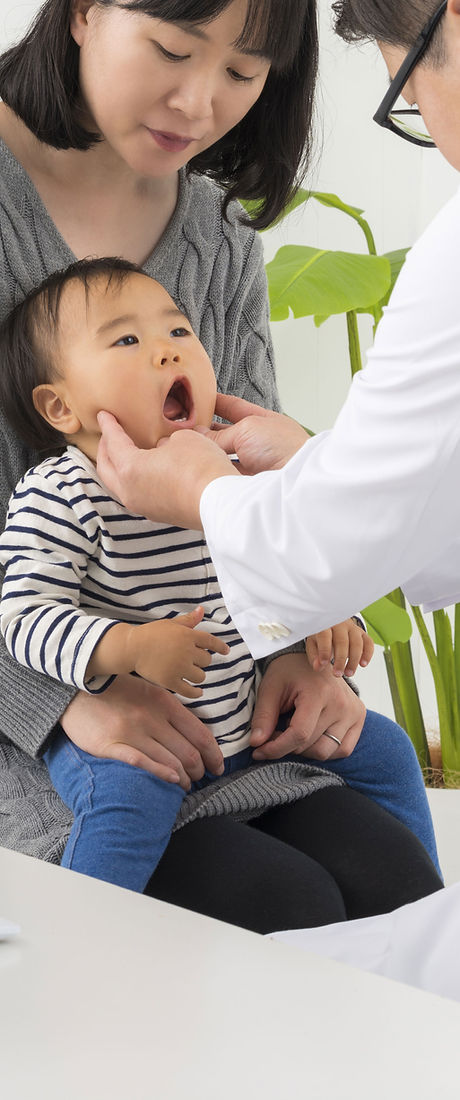 Doctor examining a baby with mother present